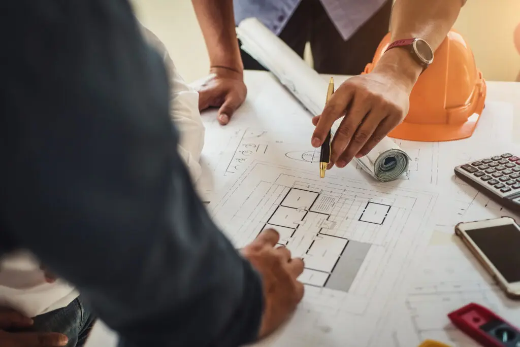 Tile installation planning by Expert Tile & Flooring in South Florida. Blueprints and tools on a desk.