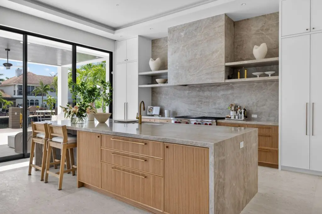 Modern kitchen with marble countertops and natural wood cabinets, installed by Expert Tile & Flooring in South Florida.